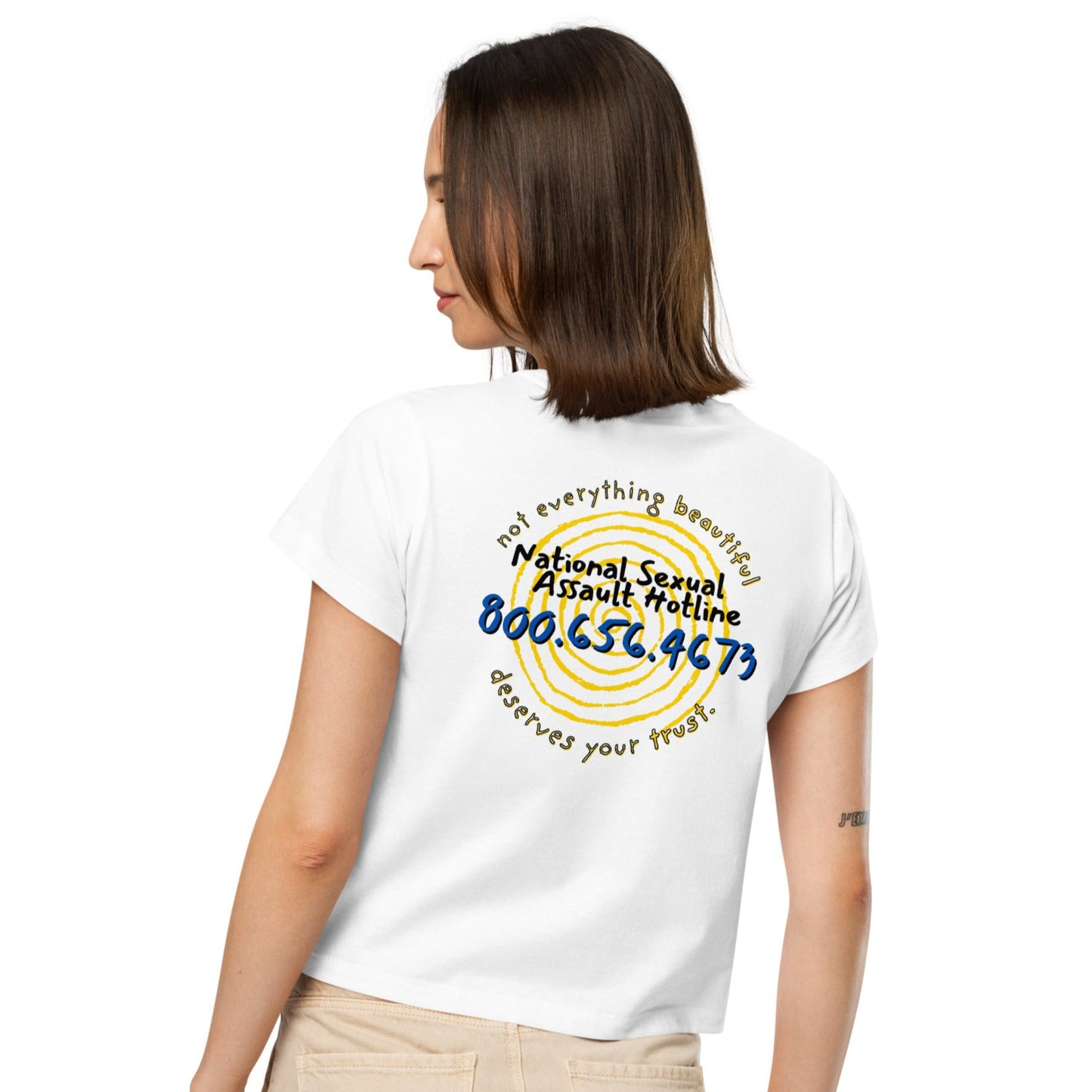 Female model wearing Not Everything Beautiful high-waisted t-shirt back view with hotline text and spiral portal.